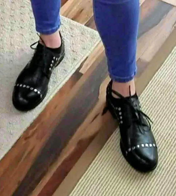 These are black leather women's oxfords with blue laces and a bright blue interior. The shoes feature silver rivets on the toecap and along the sides.